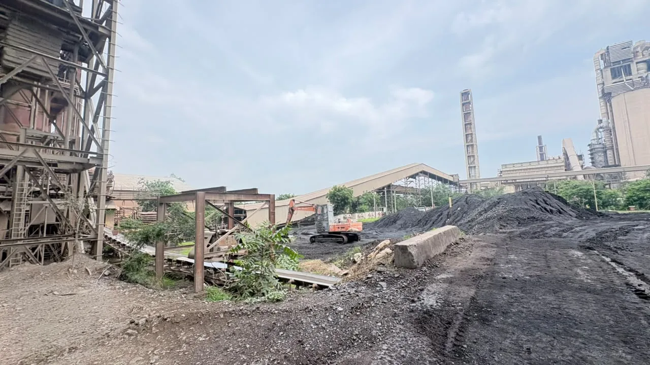 Bulk material stockpiles beside plant structures